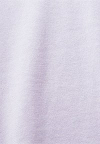 Vue en gros plan d'un tissu tricoté lavande clair avec des coutures fines et régulières et une texture douce.