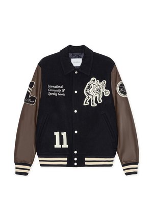 Veste en laine bleu marine avec manches en cuir marron, rayures crème, motifs brodés et le numéro 11 en grand sur le devant.