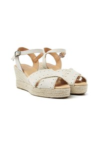 White espadrille wedge sandals with cross-strap design, textured fabric, and jute-wrapped heel. Features adjustable ankle strap and open toe.