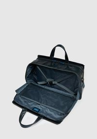 Schwarze Reisetasche mit geräumigem Inneren, inklusive Netzfächern und verstellbaren Gurten. Verfügt über strapazierfähigen Stoff und robuste Griffe.