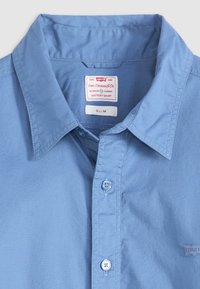 Lichtblauw langemouwen shirt met een button-up kraag, slim fit en een merkteken. Beschikt over bijpassende knopen en een gladde stoftextuur.