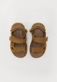 Bruna sandaler för barn med dubbla kardborreband, texturerad brun innersula och flexibla gummisulor. Lätt och avslappnad design.