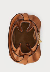 Brązowa skórzana torebka z falującymi górnymi brzegami, pojedynczym paskiem i złotym akcentem. Wnętrze wydaje się miękkie i nieustrukturyzowane.