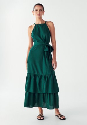 Grünes, ärmelloses Maxikleid mit einem taillierten Oberteil, einem Bindegürtel in der Taille und einem gestuften Rüschensaum. Weicher Stoff mit glatter Textur.