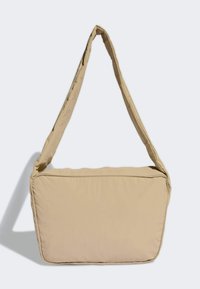 Beżowa torba na ramię o miękkiej, wyściełanej konstrukcji, z szerokim, regulowanym paskiem i prostokątnym kształtem z zaokrąglonymi krawędziami.