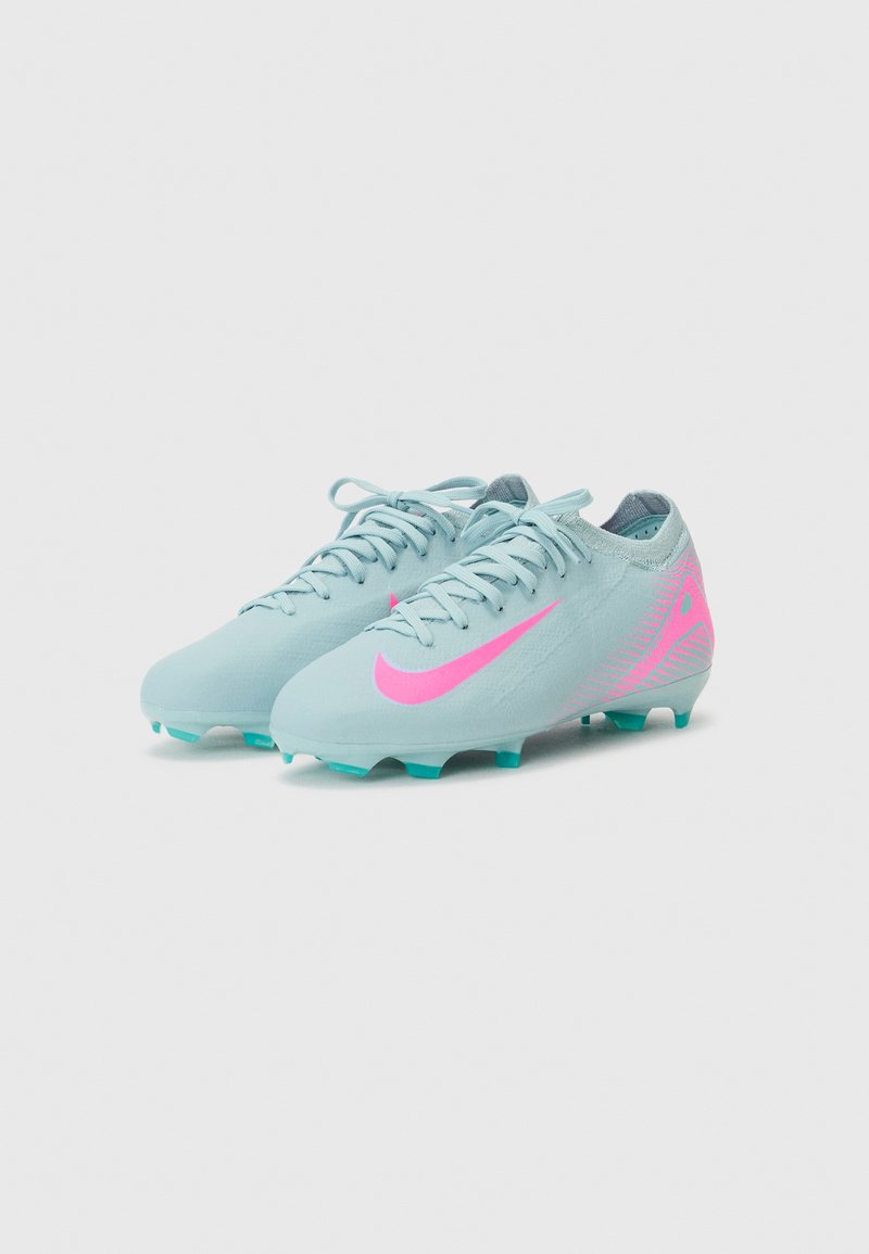 Des crampons de football bleu clair avec un logo Nike rose, une tige texturée et des crampons turquoise pour l'adhérence. Ils possèdent des lacets et un design épuré.