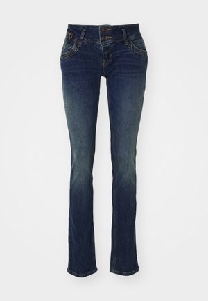 Jeans de azul escuro com um corte slim, apresentando uma cintura de botão duplo, cinco bolsos e uma textura ligeiramente desbotada nas coxas.