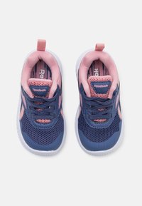 Zapatillas Reebok con una parte superior de malla azul marino, detalles en rosa y suela blanca; cuentan con cordones, una pestaña en el talón y un forro estampado.