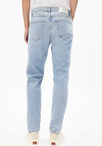 Jasnoniebieskie jeansy z denimu o prostym kroju, z tylną metką, dwoma tylnymi kieszeniami i subtelną wyblakłą fakturą.