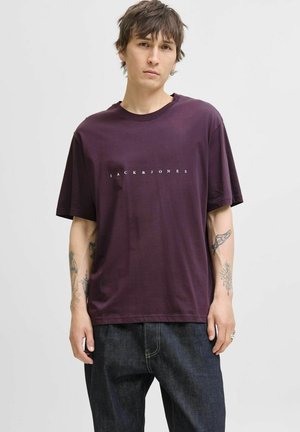 Lilla bomulds t-shirt med korte ærmer og rund hals, med et hvidt logo "JACK & JONES" trykt over brystet.