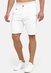 Witte katoen shorts met opgerolde zoom, voorzien van een knoopsluiting en een klein logo label. Gecombineerd met witte sneakers voor een casual uitstraling.