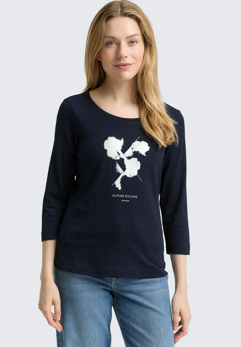 Navyblaues Langarmshirt mit Rundhalsausschnitt, ausgestattet mit einem weißen grafischen Design und dem Text "ALPINE ESCAPE." Weicher Stoff und lockere Passform.