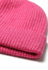 Bonnet en tricot côtelé rose, fabriqué en laine douce, avec un revers replié et une texture légèrement duveteuse. Design simple et chaud, adapté aux temps froids.
