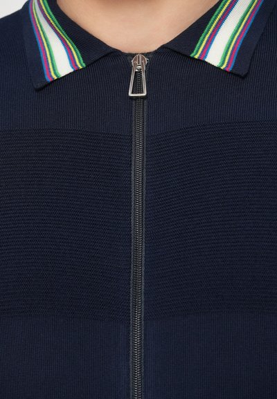 Tmavomodrý sveter na zips s textúrovaným telom, s viacfarebným pásikavým golierom a strieborným zipsom.