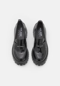 Czarne lakierowane buty wsuwane na grubym spodzie. Posiadają gładkie wykończenie oraz detal z logo na przednim pasku.