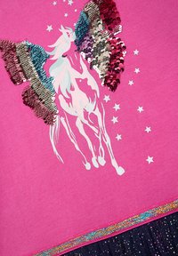 Helles pinkes Shirt mit einem paillettenbesetzten Einhorndesign in mehreren Farben. Verfügt über silberne Sterne und einen glitzernden Saum. Weicher Stoff.