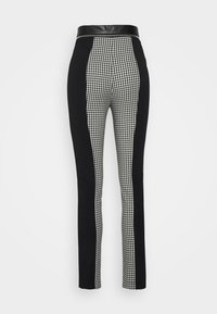 Zwart-witte op maat gemaakte broek met een hoge zwarte taille en zijpanelen in een klein geruit patroon, met een gladde textuur.