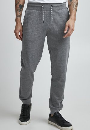 Gray sweatpants made of soft fabric, featuring an elastic waistband, drawstring closure, side pockets, and tapered ankles.