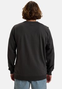 Mørk grå sweatshirt med lange ærmer, rund hals, ribbede manchetter og kant, samt et lille mærke ved nakkekanten bagpå. Blød stofstruktur.