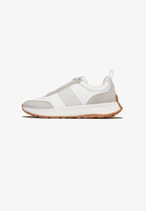 Witte en lichtgrijze lage sneaker met beige suède accenten, witte zool en bruine gestructureerde buitenzool, zijaanzicht.