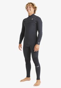 Czarny pianka neoprenowa z długimi rękawami i spodniami, z okrągłym dekoltem, teksturowanymi panelami oraz logo na klatce piersiowej i dolnej części nogi.