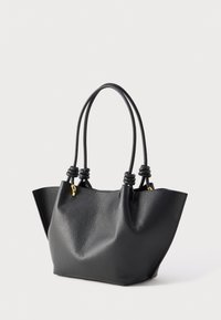 Μαύρη τσάντα ώμου από δερματίνη με υφή, με διπλούς δεμένους χειρολαβές και μικρές χρυσές μεταλλικές λεπτομέρειες, που στέκεται όρθια σε λευκό φόντο.