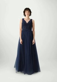 Abito da sera blu navy con scollatura a V, corpetto in pizzo e gonna in tulle fluente. Design senza maniche con una trama a strati.