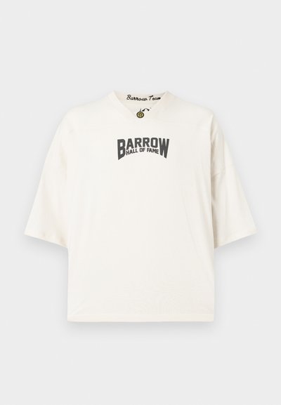 Cream short-sleeve t-shirt with a V-neck and loose fit. Features black "BARROW HALL OF FAME" text in a bold font across the front.