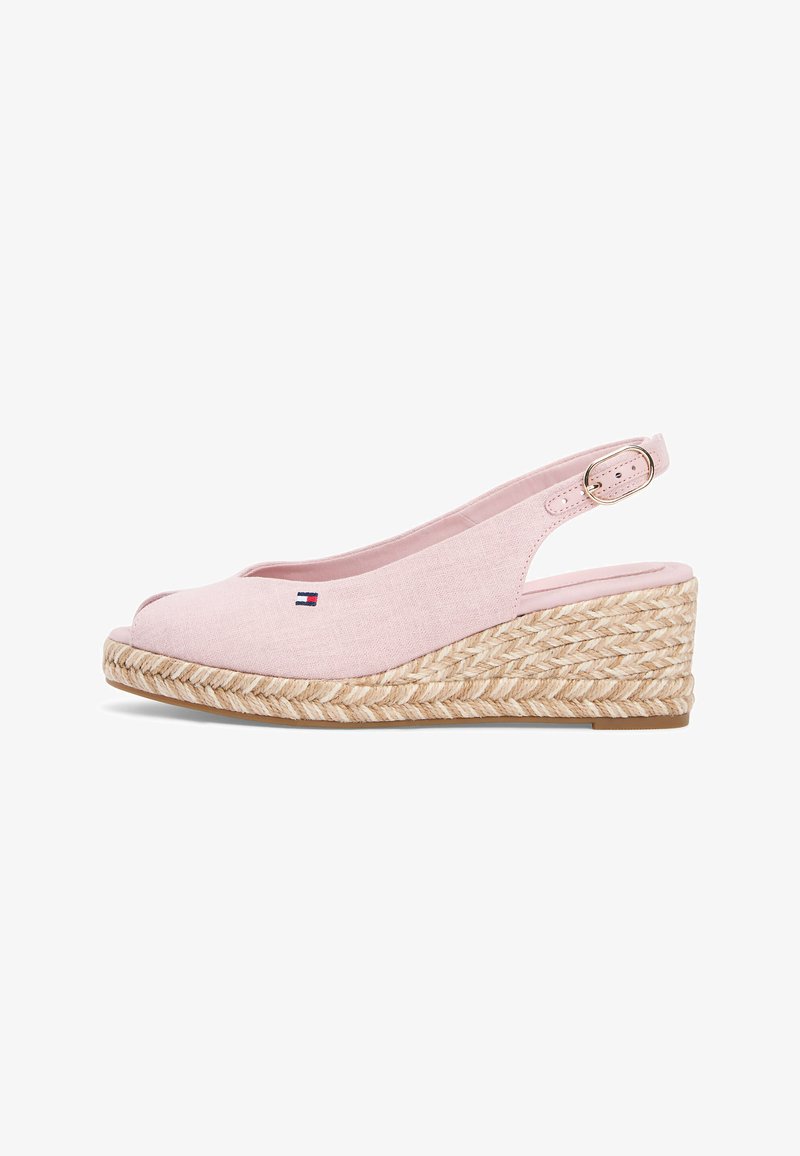 Sandale compensée rose clair avec bride arrière, bout ouvert, semelle plateforme en jute tressé, et petit logo drapeau sur le côté supérieur.