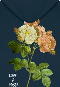 Sudadera navy con un diseño floral que presenta rosas blancas y rosas, hojas verdes detalladas y el texto "AMOR & ROSAS" en una fuente blanca.