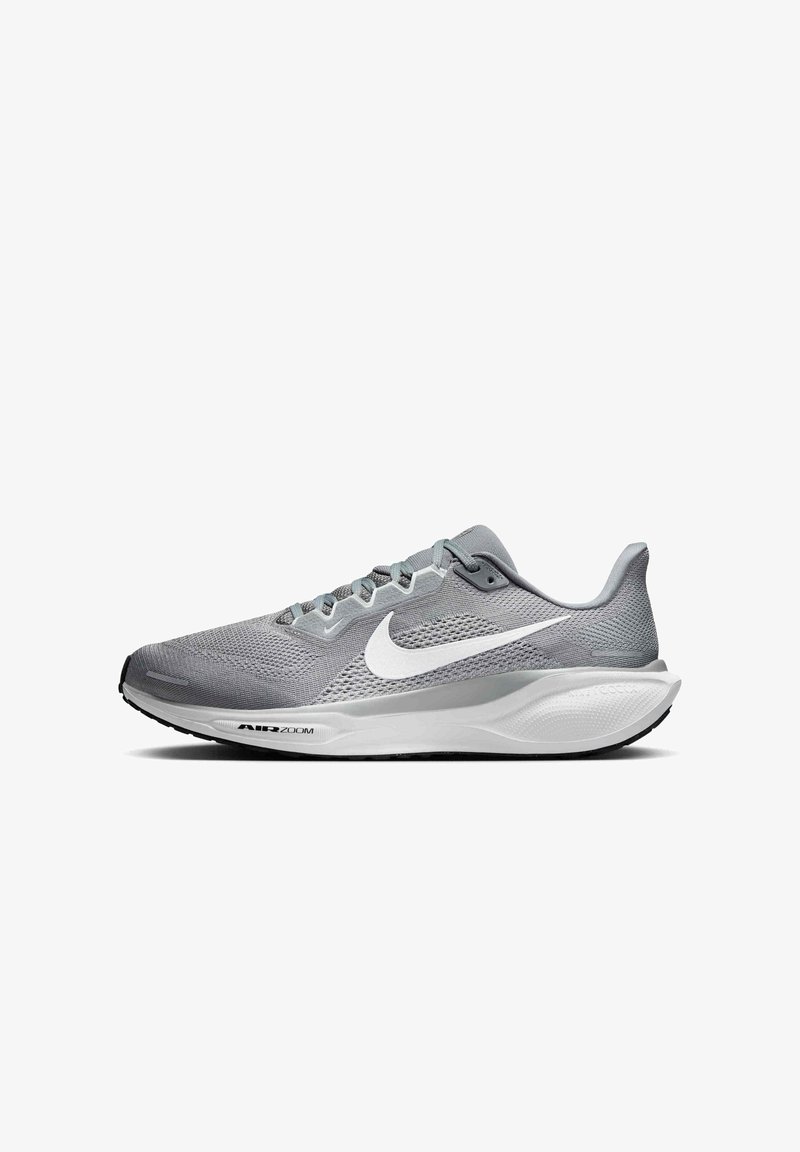Chaussure de course Nike Air Zoom grise avec logo Swoosh blanc et semelle rembourrée vue de côté sur fond blanc.