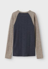 Langsleeve shirt met een donkerblauwe ribbenlichamen en lichtbeige geruite mouwen met contrasterend stiksel langs de naden.