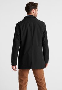 Schwarzer, wasserabweisender Mantel mit tailliertem Schnitt, ausgestattet mit einem Reverskragen, langen Ärmeln und einem geraden Rückendesign.