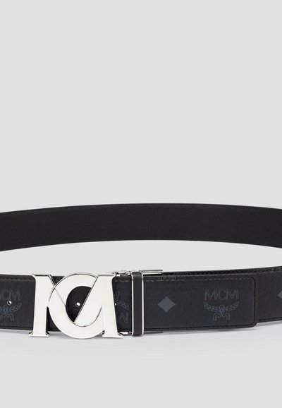 Black leather belt with a silver logo buckle. Features embossed pattern with "MCM" and diamond shapes. Smooth texture, modern design.