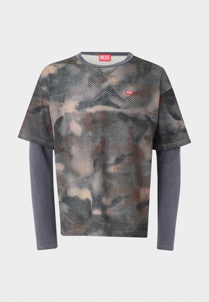 Πουκάμισο κοντομάνικο διάτρητο με σχέδιο παραλλαγής, φορεμένο πάνω από απλές γκρι μακριές μανσέτες με κόκκινο λογότυπο Diesel στο στήθος και ετικέτα στο γιακά.