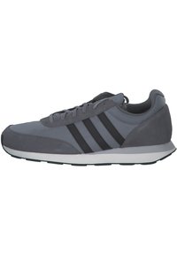 Zapatilla deportiva gris con parte superior de tela suave y acentos de ante. Presenta tres rayas negras y una media suela blanca con suela texturizada.