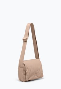 Beige vadderad axelväska med en platt, rektangulär form, som har ett brett rem och en vikflik. Slät textur med minimal detaljering.