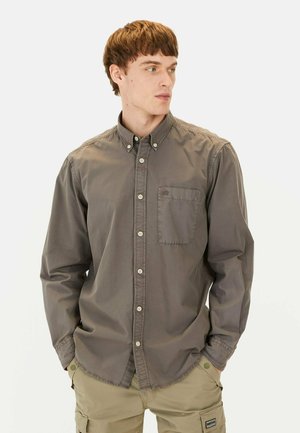 Gray button-up shirt in medium-weight fabric with a chest pocket, button placket, and collar. Features subtle stitching and a relaxed fit.