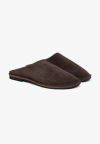 Brązowe zamszowe klapki slip-on o gładkiej teksturze, lekko spiczastym nosku i przeszytym wykończeniu na spodzie. Minimalistyczny design z niskim obcasem.