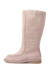 Stivale in suede beige fino al ginocchio con texture liscia, punta rotonda e cuciture minime. Dotato di suola in gomma piatta e di un'etichetta con marchio.