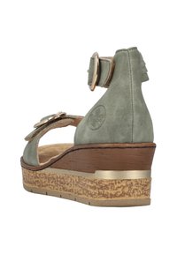 Sandal a zeppa verde in suede con punta tonda, cinturino alla caviglia con ferramenta dorata e suola piatta di colore marrone testurizzato.