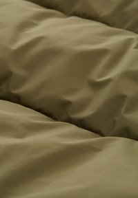 Olivengrønne stof med en blød, glat tekstur, der har subtile folder, som skaber et lagdelt udseende. Ideel til sengetøj eller ydertøj.