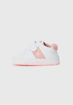 White sneaker with pink accents. Features a Velcro strap and laces, textured sides, and a smooth sole. Logo on the side.