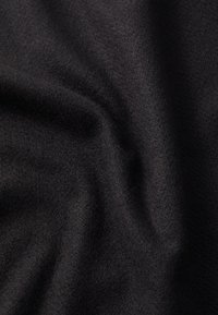 Zwarte stof met een zachte, gestructureerde oppervlakte, die subtiele variaties in tint vertoont en een soepele val heeft. Ideaal voor kleding of stoffering.