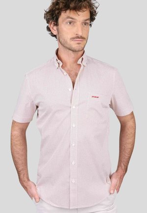 Chemise à manches courtes à boutons de couleur rose clair avec de petits points foncés, dotée d'une poche poitrine et d'un léger détail de logo. Tissu léger, design du col.