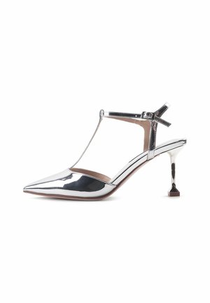 Metallinhoher silberner Absatzschuh mit spitzer Zehenpartie, T-Riemen-Design und einzigartigem quadratischen Absatz. Glatte Oberfläche mit minimaler Verzierung.