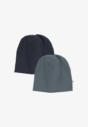 Due cappelli beanie: uno blu navy scuro, l'altro verde teal spento. Realizzati in un tessuto morbido e elasticizzato con una texture liscia e un piccolo etichetta del logo sul cappello teal.