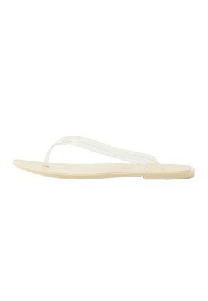 Beige flache Flip-Flop-Sandale mit dünnem transparentem Riemen über einer glatten Sohle, von der Seite vor weißem Hintergrund gezeigt.