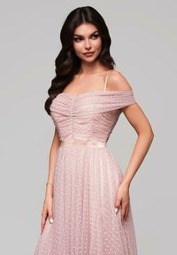 Robe décolletée en rose clair, avec un tissu froncé, une superposition transparente à pois et une taille cintrée avec une ceinture en satin.