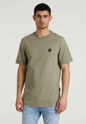 T-shirt verde oliva a maniche corte in cotone. Presenta un collo rotondo e un piccolo patch con logo nero sul lato sinistro del petto.
